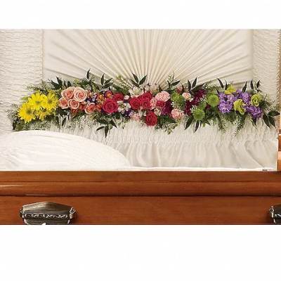 Colorful floral casket spray on a white casket