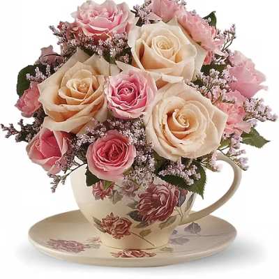 Pink and cream roses arranged in a floral teacup with saucer