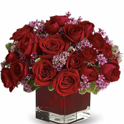 Red roses and small purple flowers arranged in a square glass vase
