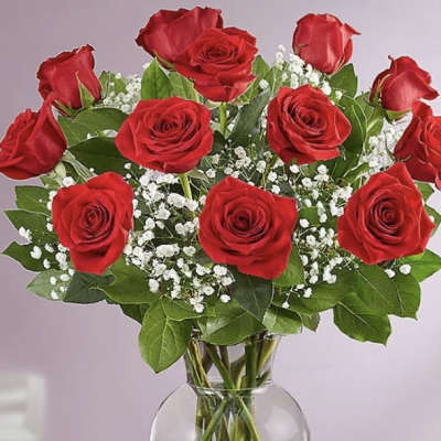 Bouquet of red roses with baby's breath in a clear glass vase