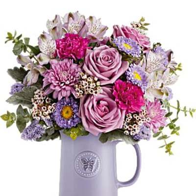 Lavender and pink mixed flower arrangement in a lavender ceramic mug
