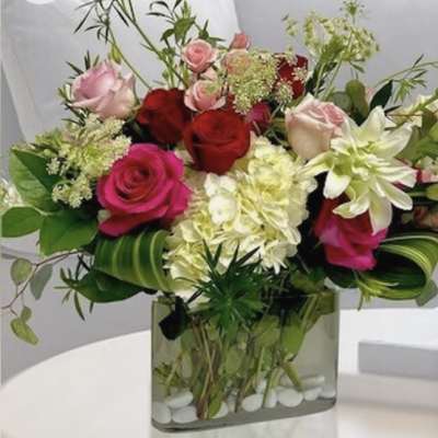 Mixed roses and white blooms in a square glass vase