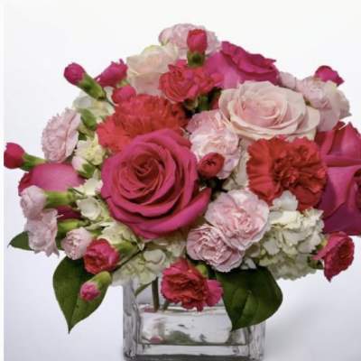 Pink and white roses with carnations in a clear glass vase