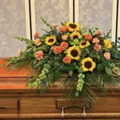 Casket spray with sunflowers and orange roses