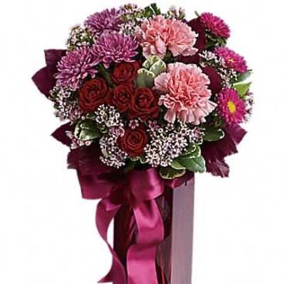 Tall berry-toned bouquet with pink carnations, red roses, and purple mums in a magenta vase