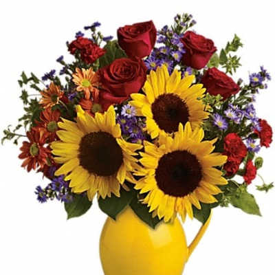 Bouquet of sunflowers, red roses, and purple flowers in a yellow pitcher