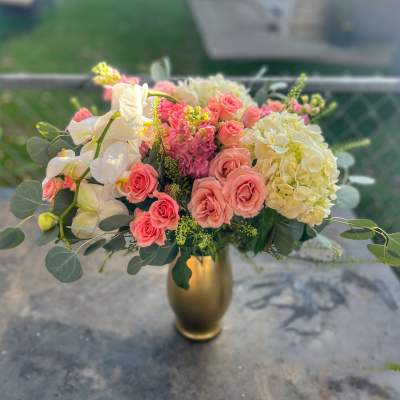 Pink roses and white orchids in a gold vase