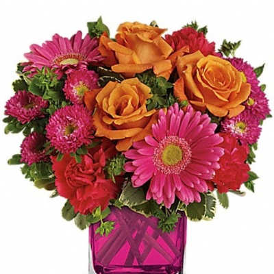 Bouquet of orange roses and pink daisies in a magenta glass vase