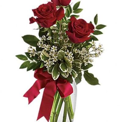 Red roses in a glass vase with a red ribbon