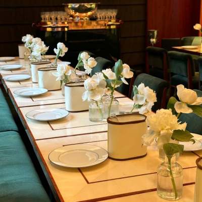 White floral centerpieces in small glass vases on a set dining table