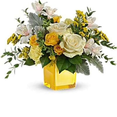 Yellow and white flower arrangement with roses and alstroemeria in a yellow glass cube vase