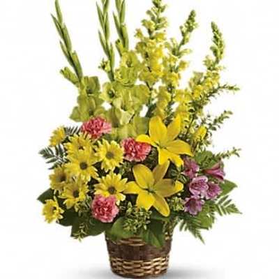 Tall yellow and pink mixed flower basket arrangement with lilies, daisies, and snapdragons