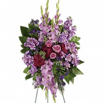 Tall purple and lavender standing spray with roses on a metal easel