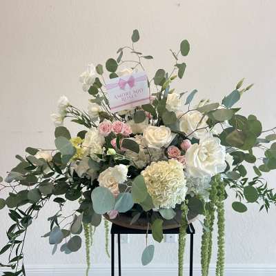 Large white and pink rose arrangement with eucalyptus and trailing greenery