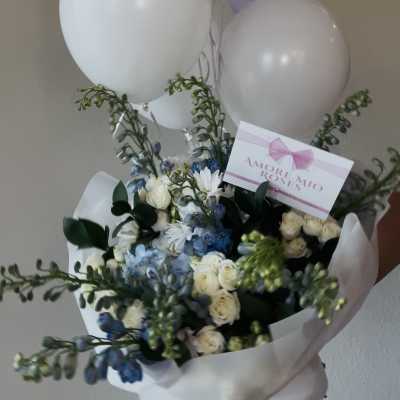 Bouquet of white and blue flowers with lavender and white balloons