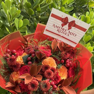 Red and orange bouquet with roses and chrysanthemums in red wrap