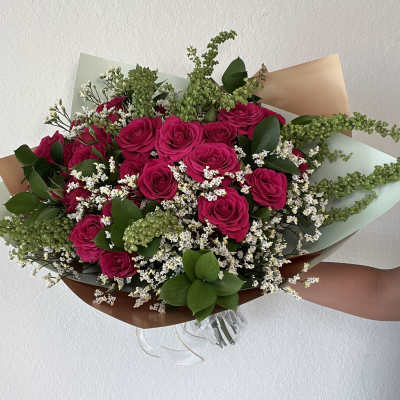 Bouquet of hot pink roses with white filler flowers and greenery