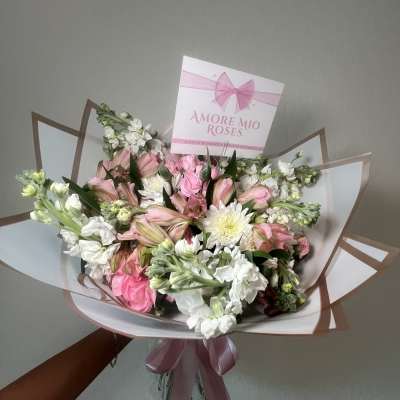 Pink and white bouquet with a ribbon and card