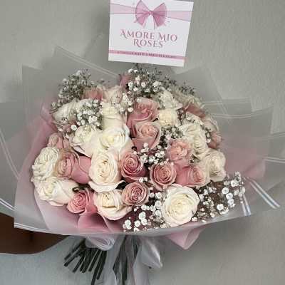 Bouquet of pink and white roses wrapped in pink paper