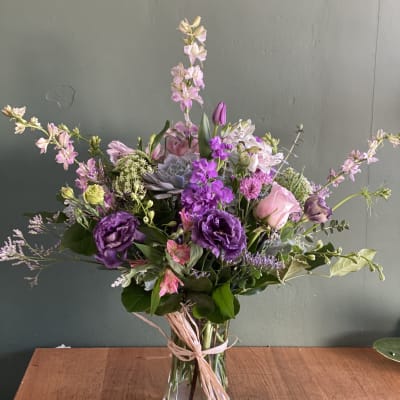 Purple and pink mixed bouquet in a clear glass vase