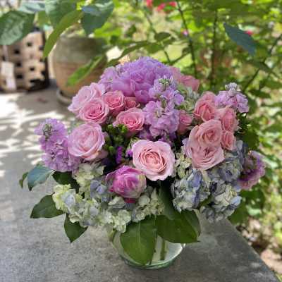 Pink roses and lavender hydrangeas in a glass vase