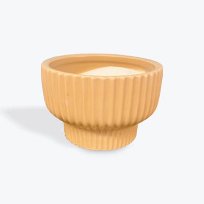 A ribbed tan ceramic planter pot on a white background.