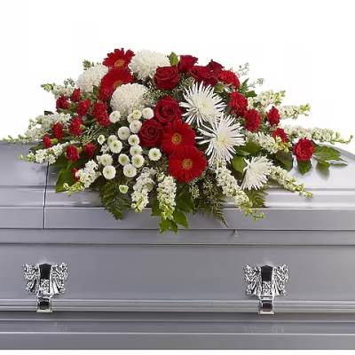Red and white floral casket spray on a silver casket