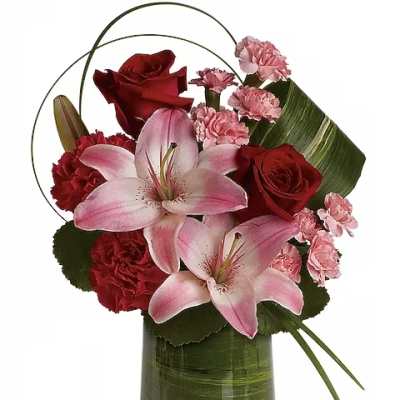 Pink lilies and red roses arranged in a green glass vase