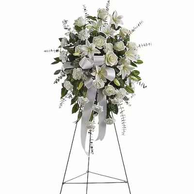 White floral standing spray on a metal easel with ribbon
