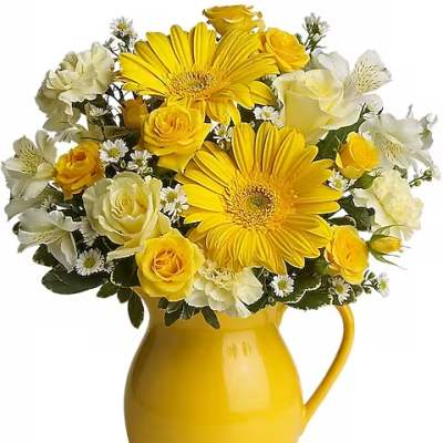 Yellow and white flower bouquet in a yellow pitcher vase