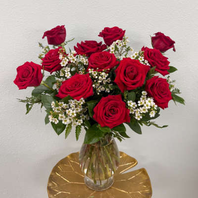 Bouquet of red roses and white filler flowers in a clear glass vase