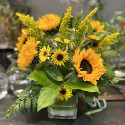 Sunflower and yellow daisy bouquet in a clear glass vase