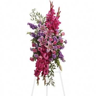 Tall pink and purple standing spray with lilies on a white easel stand