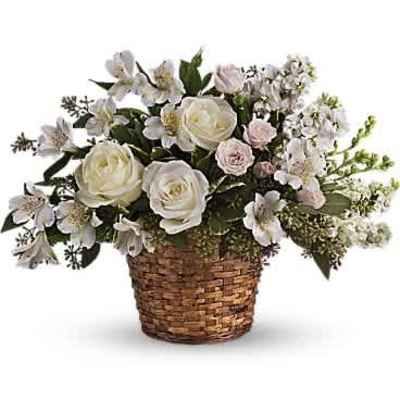 White and cream flowers arranged in a woven basket.