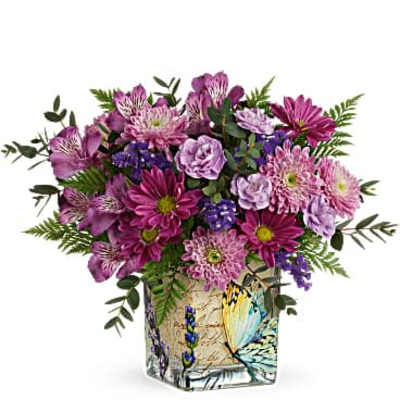 Purple and pink mixed bouquet arranged in a square glass vase with a butterfly design