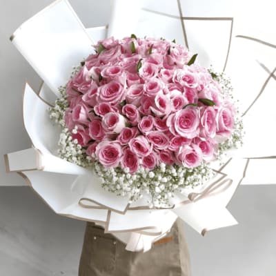 Large bouquet of pink roses wrapped in white paper