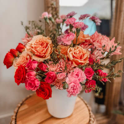 Bouquet of pink and peach roses in a white vase