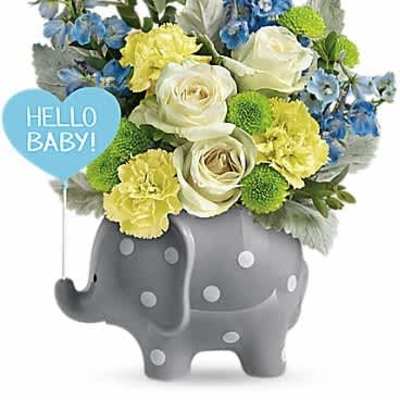 Baby-themed bouquet of blue, white, and yellow flowers in a gray polka dot elephant vase.