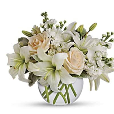 White lilies and cream roses in a round glass vase