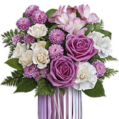 Lavender and white mixed flower arrangement in a ribbed purple glass vase