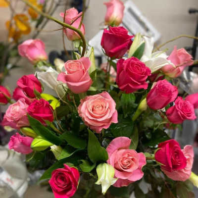 Bouquet of pink and hot pink roses with white lilies in a vase