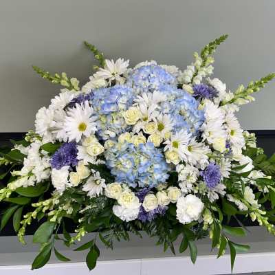 Large white, blue, and purple floral arrangement with daisies and hydrangeas