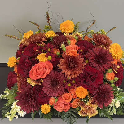 Large bouquet of red, orange, and yellow flowers in a low arrangement