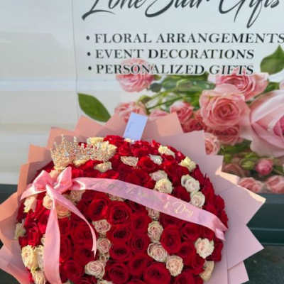 Large bouquet of red and white roses wrapped in pink paper with a ribbon