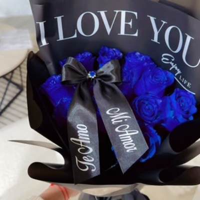 Bouquet of blue roses wrapped in black paper with a ribbon