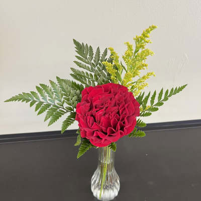 Red rose arrangement in a clear glass vase with fern and yellow filler