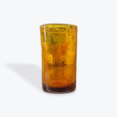Amber glass tumbler filled with an orange drink