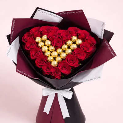Heart-shaped bouquet of red roses with gold chocolates in decorative wrap