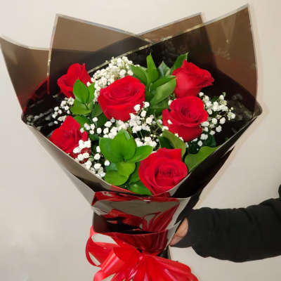 Bouquet of red roses with baby's breath in black wrap and red ribbon