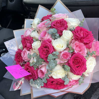Bouquet of hot pink, blush, and white roses with eucalyptus wrap